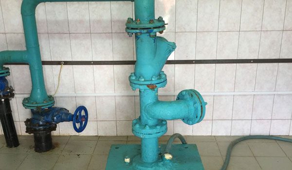 Оголовок эксплуатационной скважины и водопроводные трубы